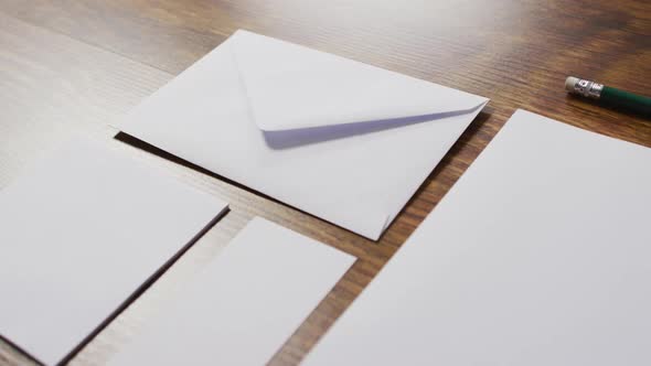 Video of envelope and white cards with copy space on wooden background