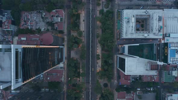 Top Down View of Cars Driving on Road and Tall Building Along Street in Mexico City