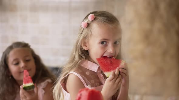 Portrait of Joyful Pretty Girl Smiling Eating Watermelon Talking with Unrecognizable Mother As