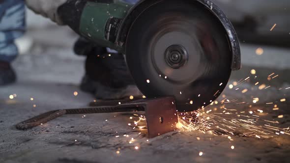 worker cuts metal with a angle grinder