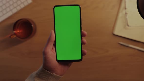 Man Using Smartphone with Green Empty Screen