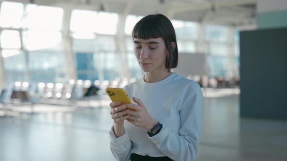 Woman Typing on Cell Phone While Waiting for Departure