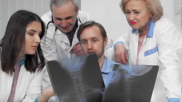 Group of Doctors Discussing X-ray Scans of a Patient Together