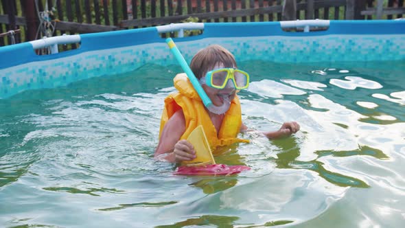 A Little Boy Swimming in the Inflatable Pool with Underwater Mask