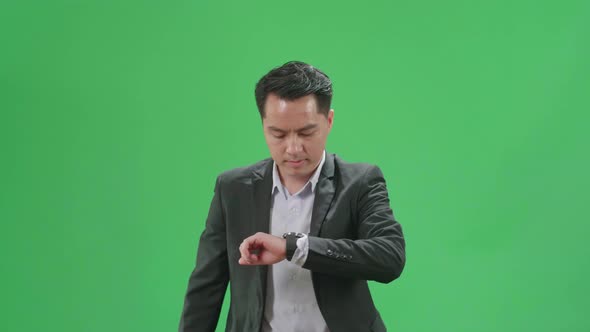 Asian Business Man Walking And Looking At Watch On Green Screen Chroma Key