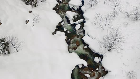 Stream Flowing Through Snow