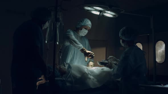 Confident Surgeon Performing Operation in Dark Sterile Clinic Emergency Room