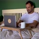Man sitting in bed working on laptop, drinking coffee - VideoHive Item for Sale