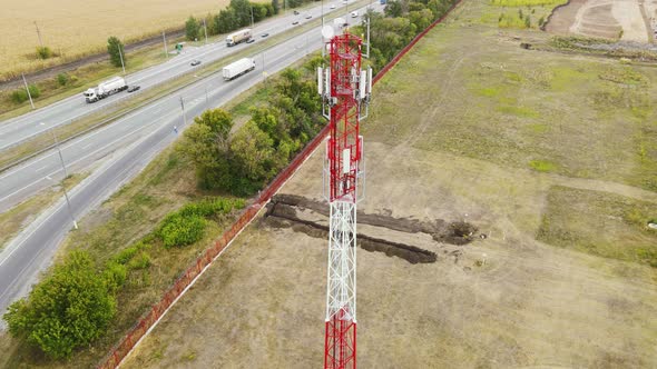 Telecommunication Antenna Receiver Tower Near Highway with Car Traffic