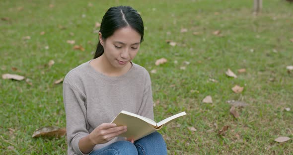 Woman read book on green grass