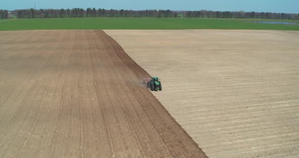 Ploughing Tractor at Field Cultivation Work Aerial View