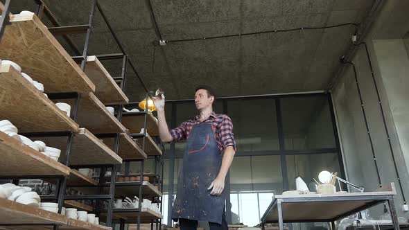 Male Potter Looking to the Handmade Vases During Work Day in the Pottery