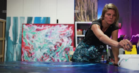 Mature woman painting inside her atelier studio at home