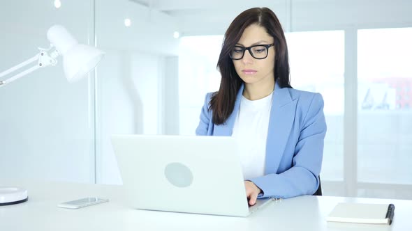 Young Businesswoman Working On Laptop in Office