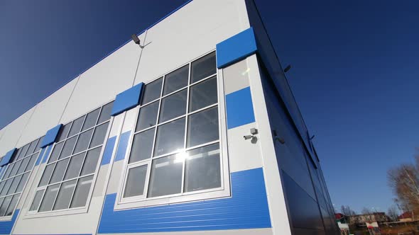 Stylish White and Blue Warehouse Building Against Clear Sky