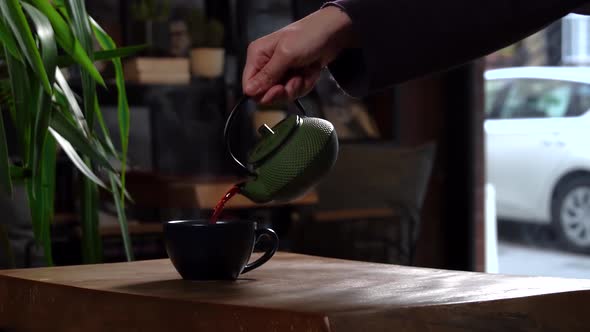 Cinematic Slow Motion Pouring Herbal Tea in Navy Blue Mug from Green Tea Pot