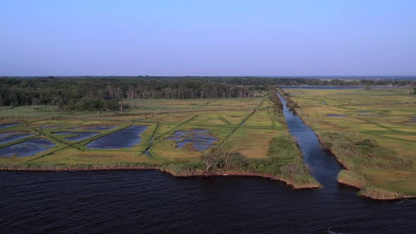 a slow aerial pan right at East Islip Marina & Park over the water looking up the long channel of th