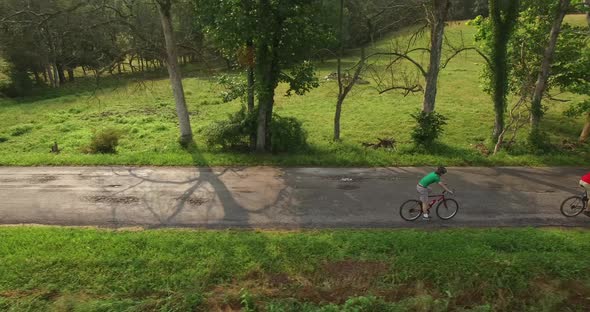 Aerial views of family bicycling along pastoral country roads.