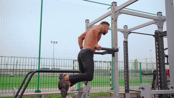 Athletic Man Pumps Up Muscles Doing PushUps Open Sports Ground with Naked Torso