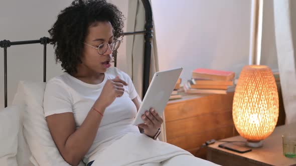 African Woman Reacting to Loss on Tablet in Bed