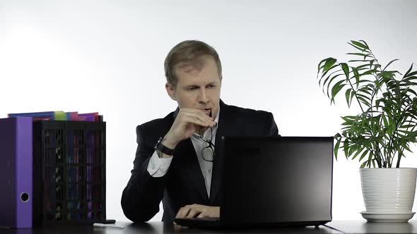 Tired Businessman Manager in Office Has a Headache Working on Laptop