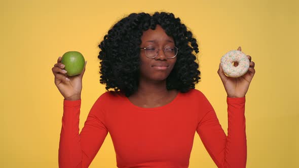 Puzzled Woman Making Choice Between Apple and Donut