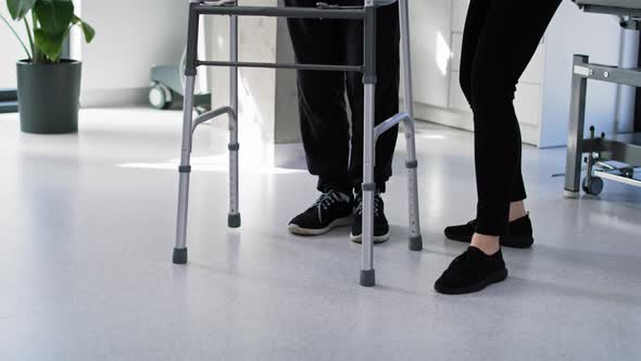 Senior man using a walker with the assistance of a nurse. Shot with RED helium camera in 8K.