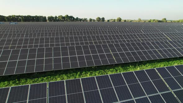 Aerial View Solar Power Station on Green Field at Sunset Solar Panels in Row