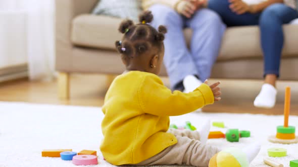 African Baby Girl Playing with Toy Blocks at Home