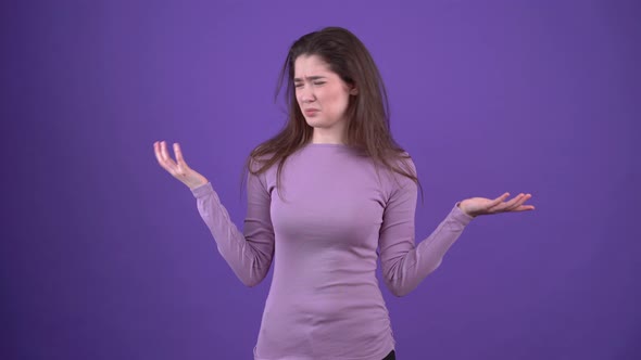 The Disgusted Young Woman Frowns and Shows Her Hands to Move Away