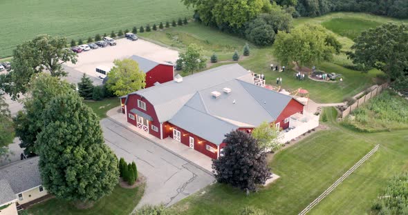 Big red barn with wedding reception behind it during a summer sunset in Wisconsin