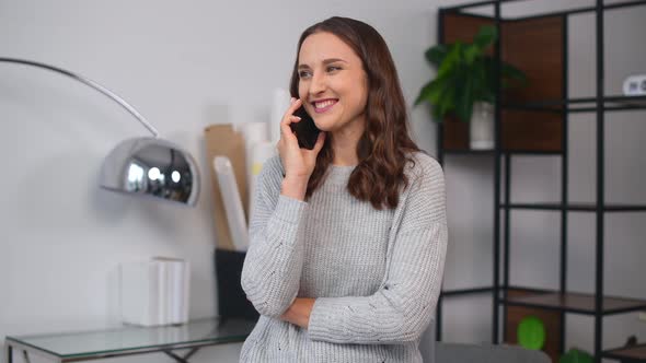 Cheerful Female Employee Has Phone Conversation