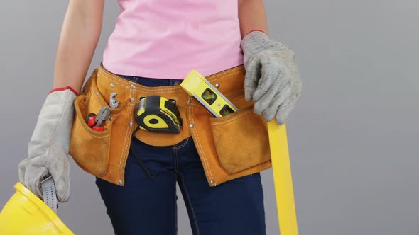 Female architect holding scale and helmet in her hands 