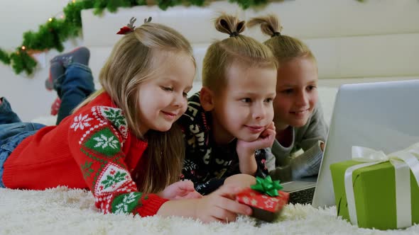 New Year's Concept Children Lie Couch Christmas Clothes Make Online Call Laptop