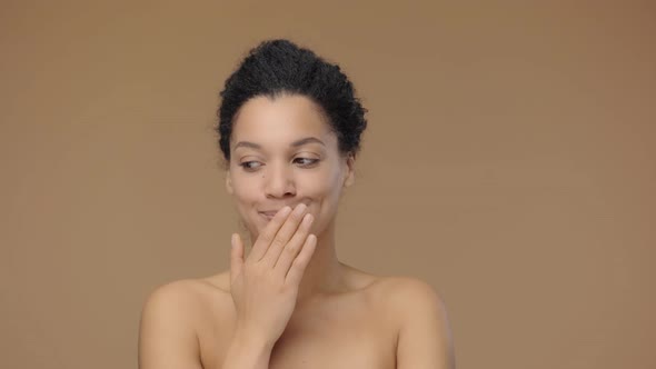 Beauty Portrait of Young African American Woman Coquettishly Looking at Camera and Showing Hush