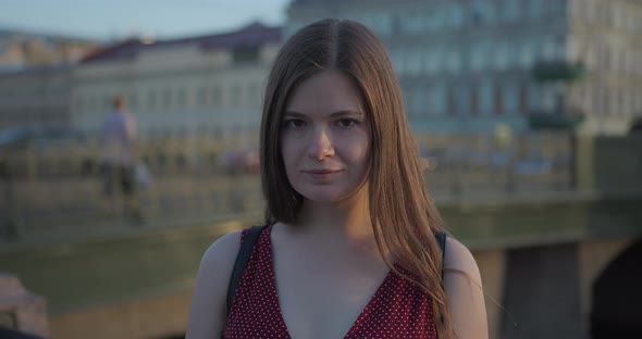 Portrait of a Young Woman in the Sun on the River Embankment in the Old Town