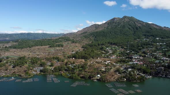 Fly over the village with view on volcano