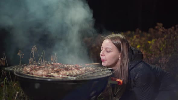 Girl Fries a Barbecue and Fanning the Fire