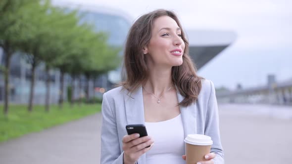 Pretty Businesswoman Walking in the Town. Drinking Tasty Coffee.