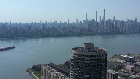 A drone view of the Hudson River from over NJ on a sunny day. The camera truck righting around a bui