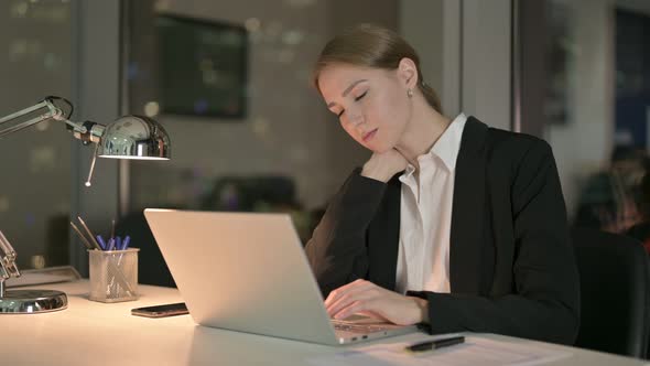Tired Businesswoman Having Neck Pain in Office at Night 