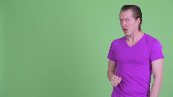 Stressed Young Man Touching Something and Looking Shocked