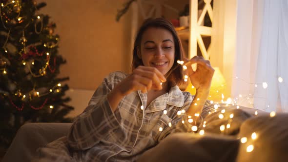 Close Up Shot Happy Dreaming Girl Holding Xmas Lights and Awaiting Miracle Happen on Christmas and