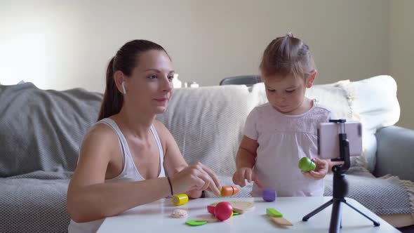 Mother with Child Streaming Online Video of Unboxing Wooden Toys. Influencer Occupation, Mommy Blog
