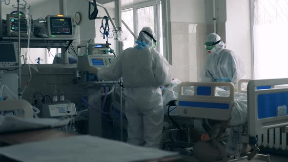 Two Health Care Workers Treating a Coronavirus Patient at an Intensive Care Bed