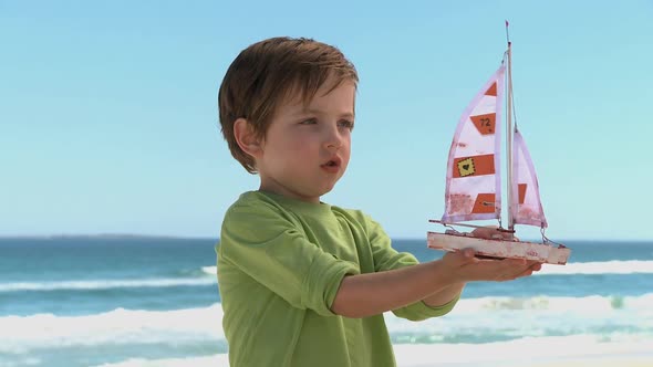 MS OF A BOY PLAYING WITH A TOY BOAT