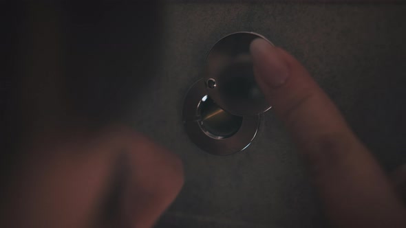 Woman Looking Through the Peephole at Night Closeup of a Finger Opening a Peephole