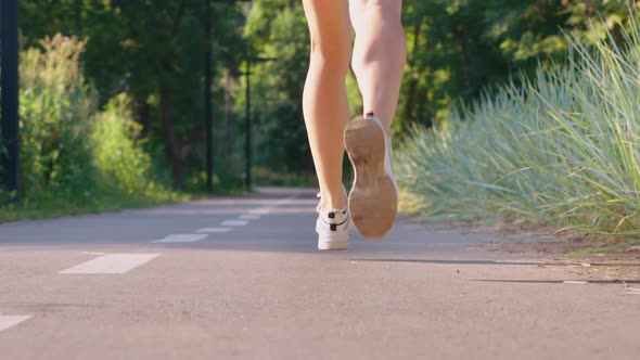 Female Feet Jogging on Road in Slow Motion