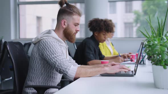 Hipster Man Working at Laptop in Office