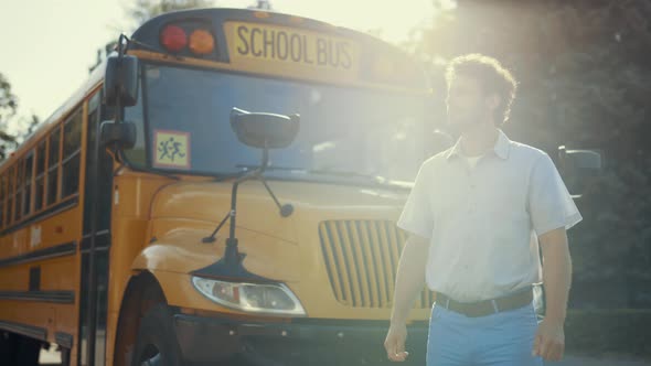 Young Schoolbus Driver Stand Near Academic Shuttle Alone